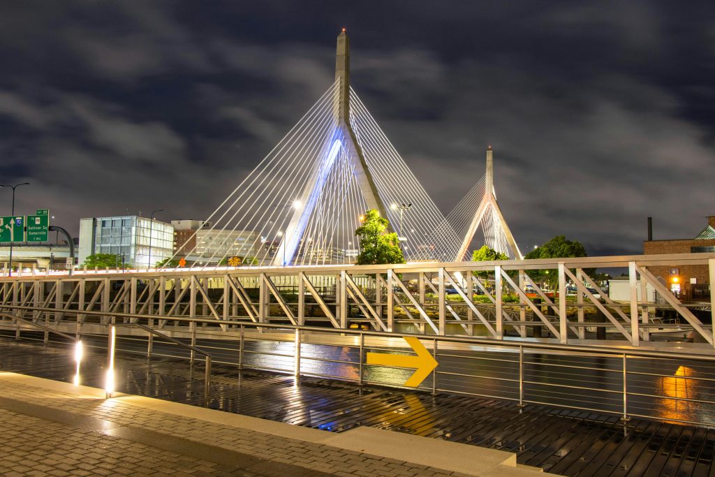 Illuminated Zakim Bridge in Boston captured at night showcasing urban architectural beauty.