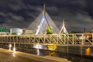 Illuminated Zakim Bridge in Boston captured at night showcasing urban architectural beauty.